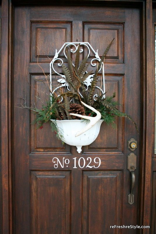 Feathers, greenery and antlers as front door decor