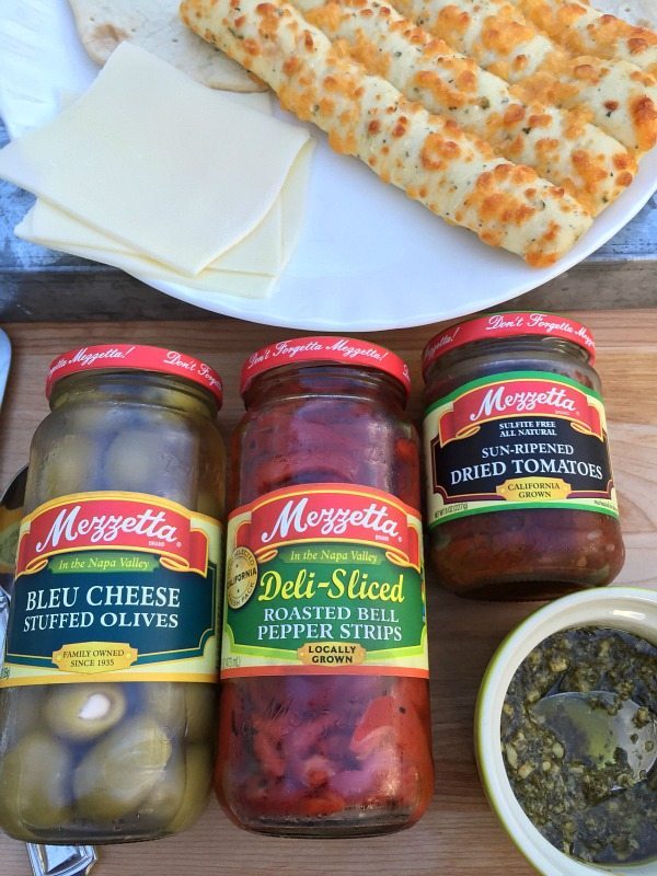 Ingredients for a quick appetizer. Pizza Bites quick and delicious with Pesto and roasted red peppers Mezzetta Olives